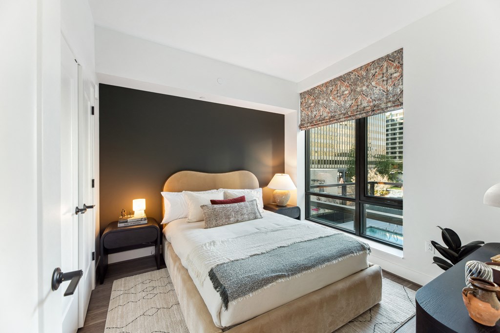 a bedroom with a bed and a large window