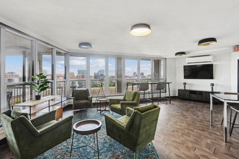 a living room with couches and chairs and a balcony with a view