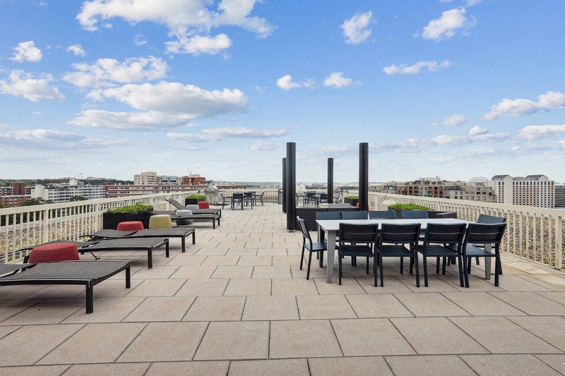 a terrace with tables and chairs on top of a roof