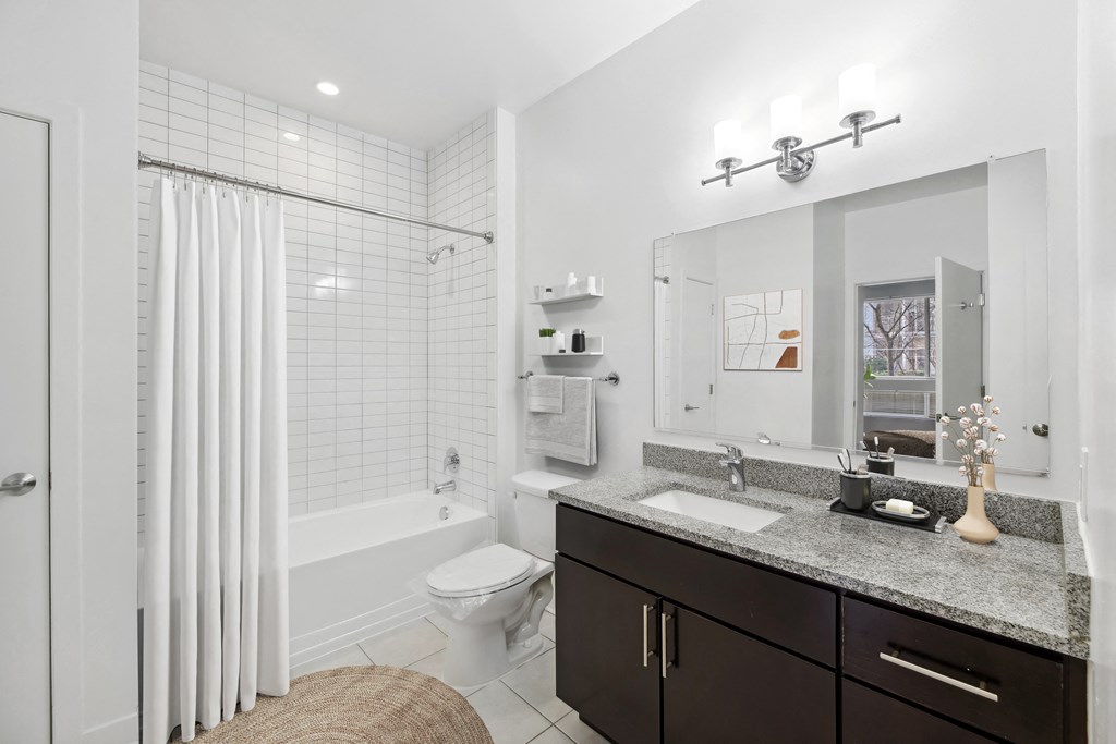 a white bathroom with a shower and a sink
