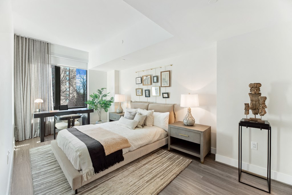 a bedroom with a bed and a desk and a window