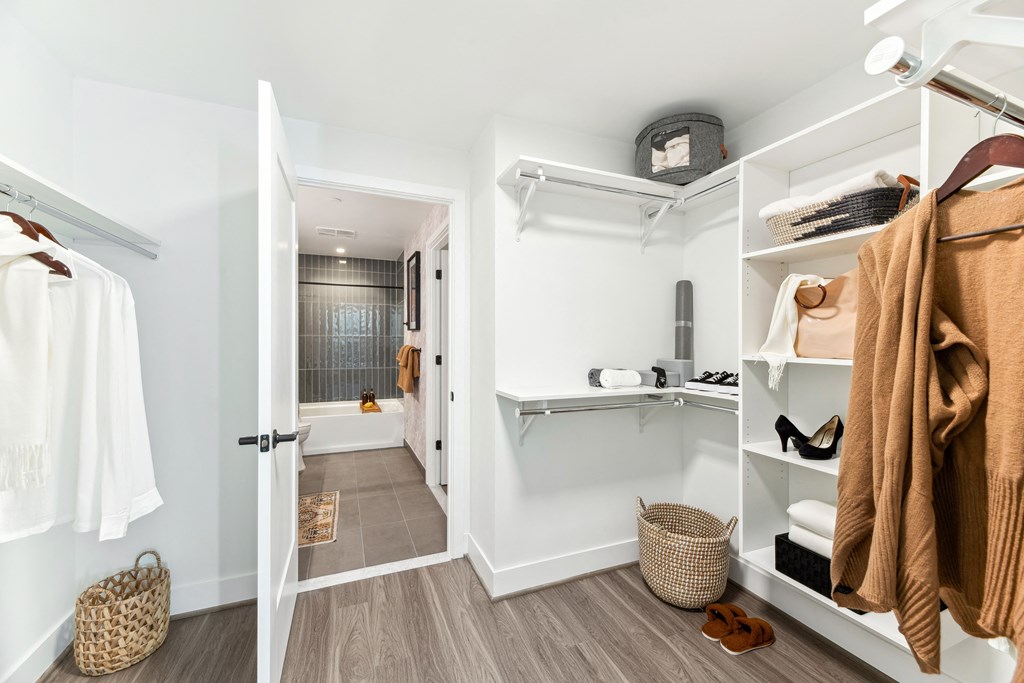 a walk in closet with towels and a shower and a sink