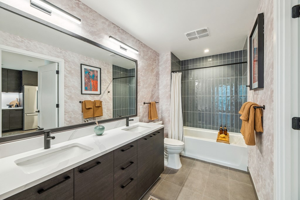 a bathroom with a large mirror and a sink and a toilet