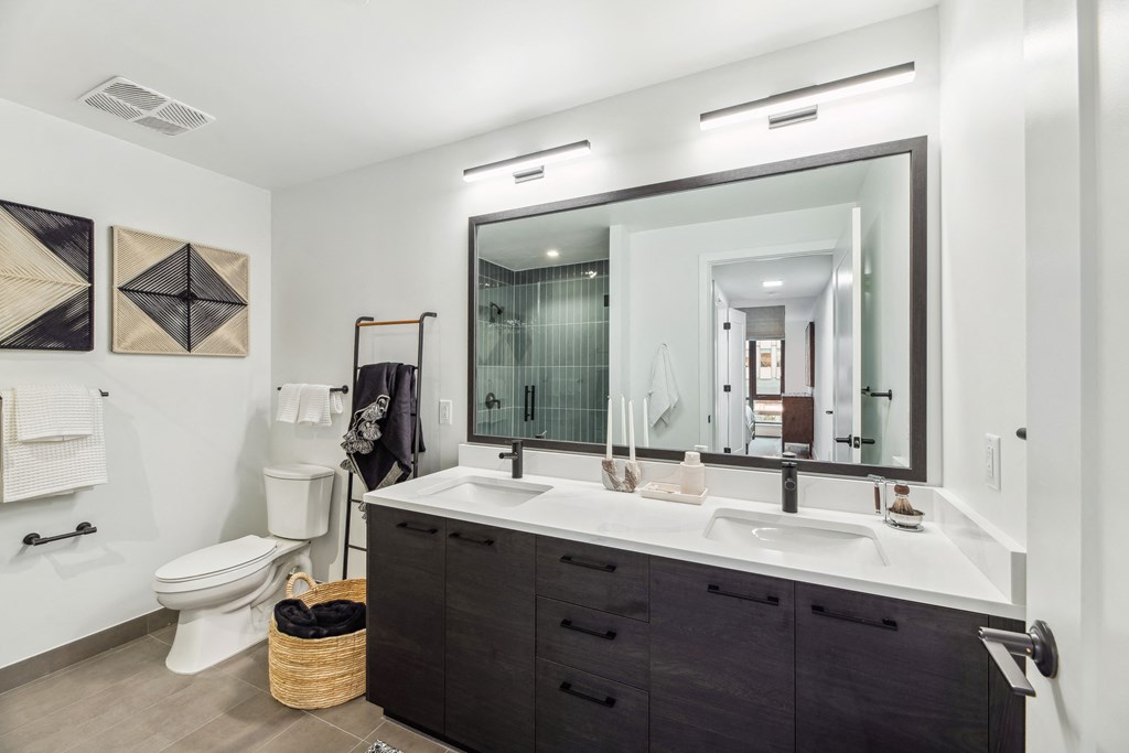 a bathroom with a large mirror and a sink and a toilet
