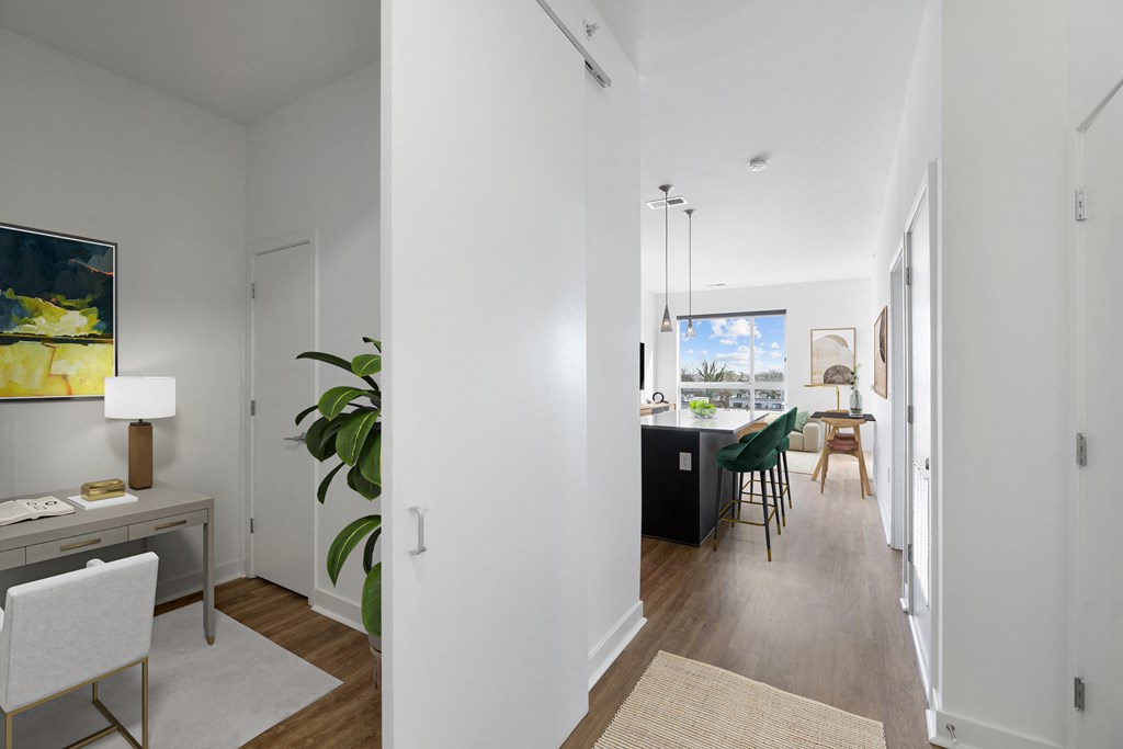 a view of a living room and dining room from the hallway of a house