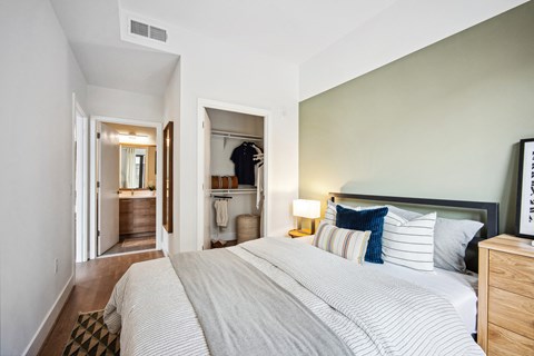 a bedroom with a large bed and a hallway to a bathroom