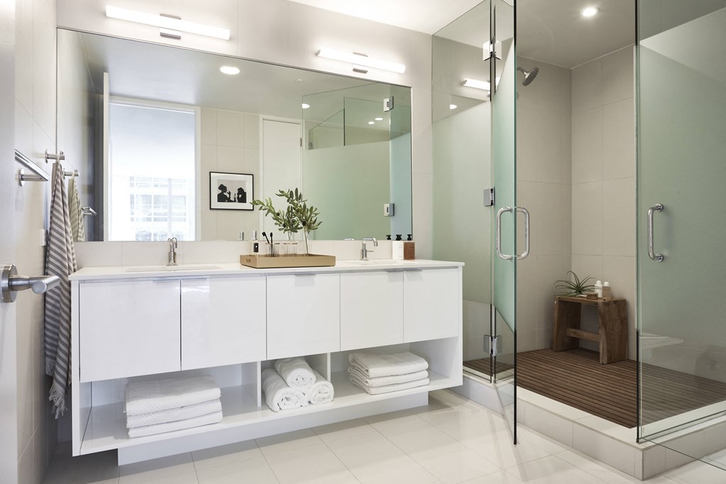 a white bathroom with a large mirror and a large sink