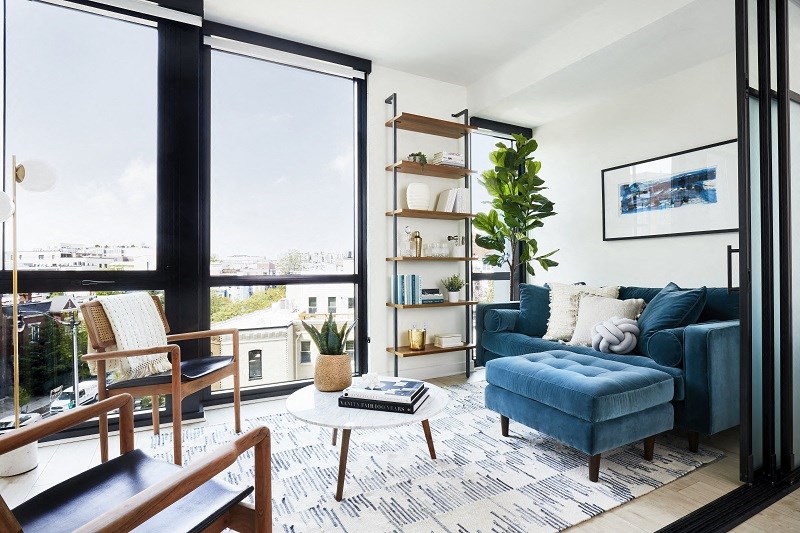 a living room with blue furniture and a large window