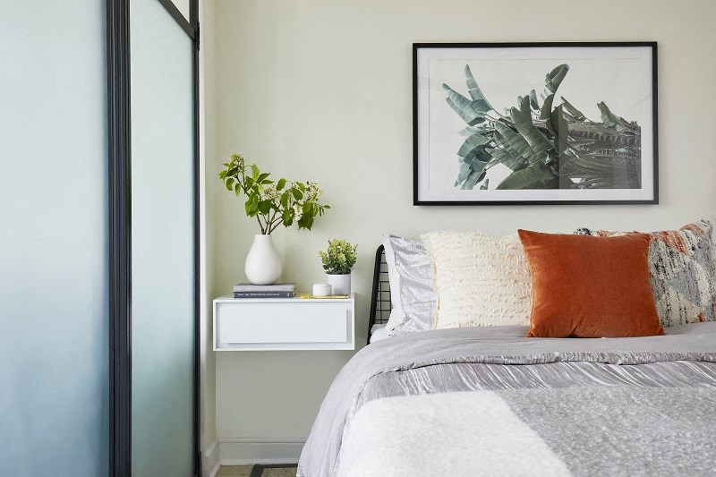 a bedroom with a bed and a picture on the wall