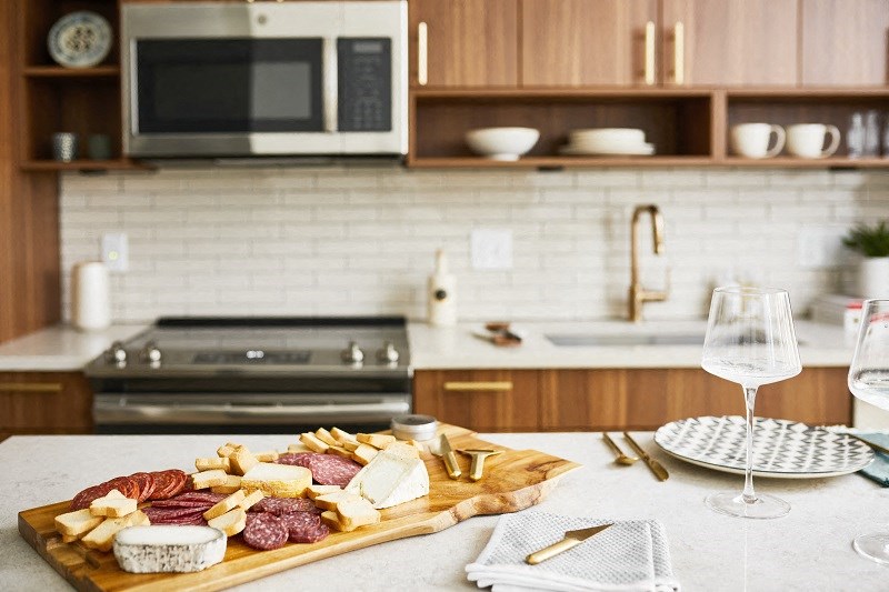 a cutting board with cheese and meats on a kitchen counter