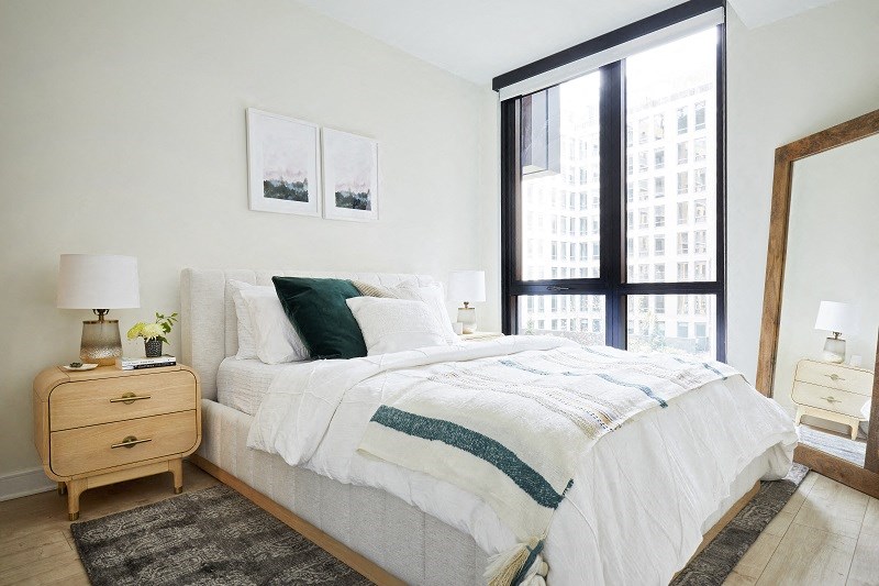 a bedroom with a bed and a large window