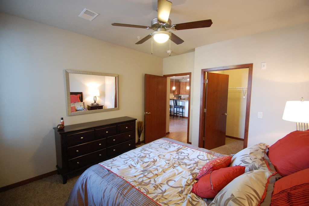 a bedroom with a large bed and a ceiling fan
