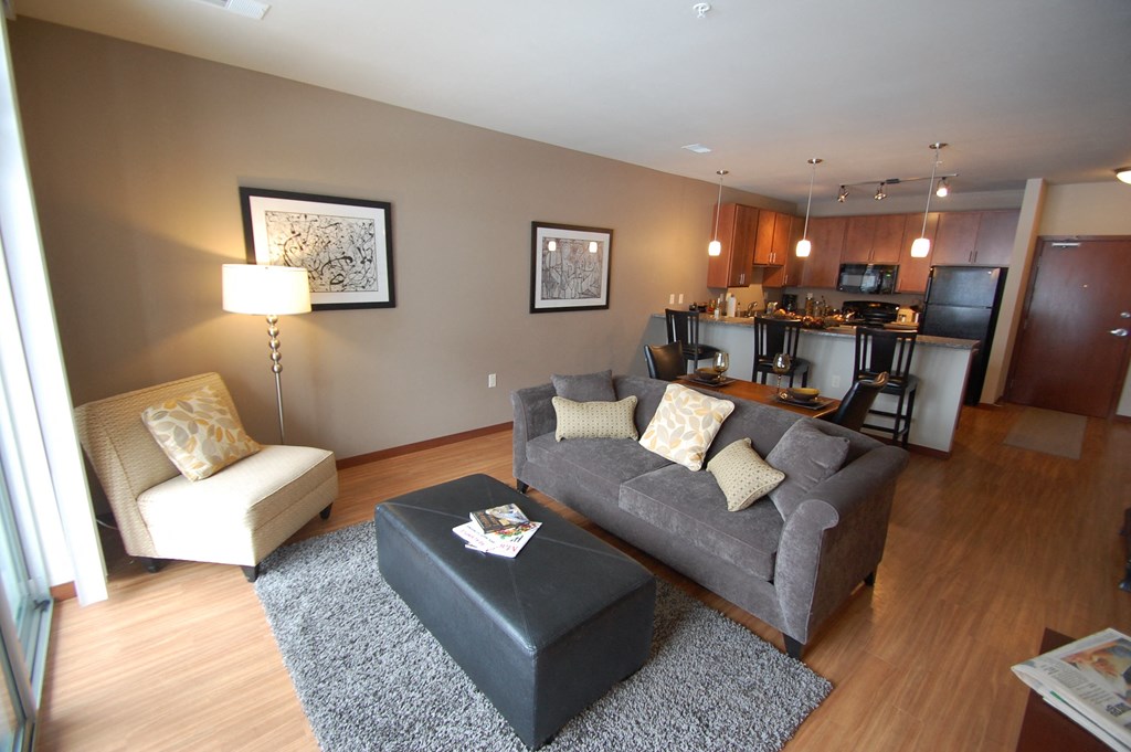a living room with a couch and a chair and a kitchen