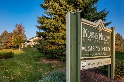 A sign for Kearney Meadows Apartment Homes with a leasing office phone number and website.
