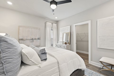 A bedroom with a large bed and a ceiling fan.