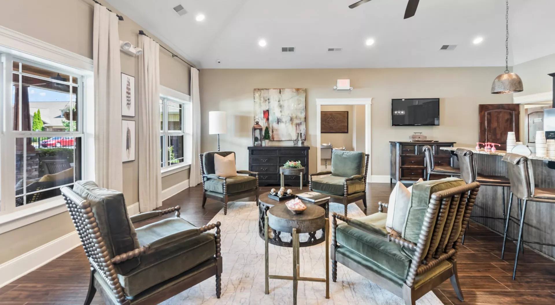 A living room with a black leather chair and a green leather chair.
