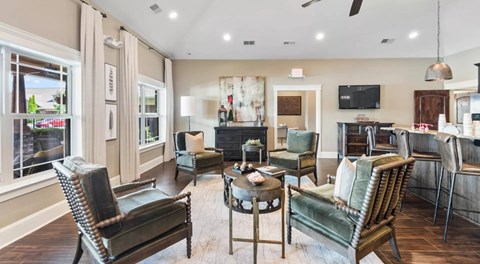A living room with a black leather chair and a green leather chair.