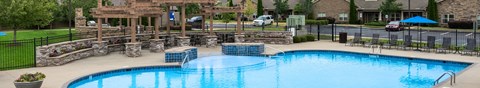 A large outdoor swimming pool surrounded by a black fence.