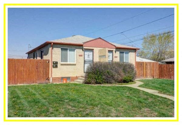 a yellow house with a yard and a wooden fence