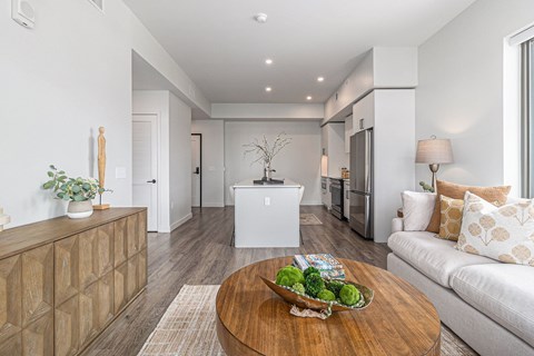 A modern living room with a wooden coffee table in the center.