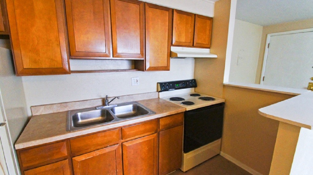 a kitchen with wooden cabinets and a stove and a sink
