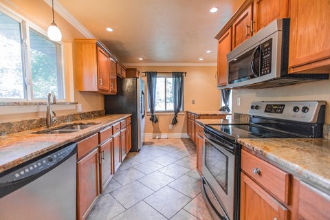 A kitchen with wooden cabinets and black appliances.