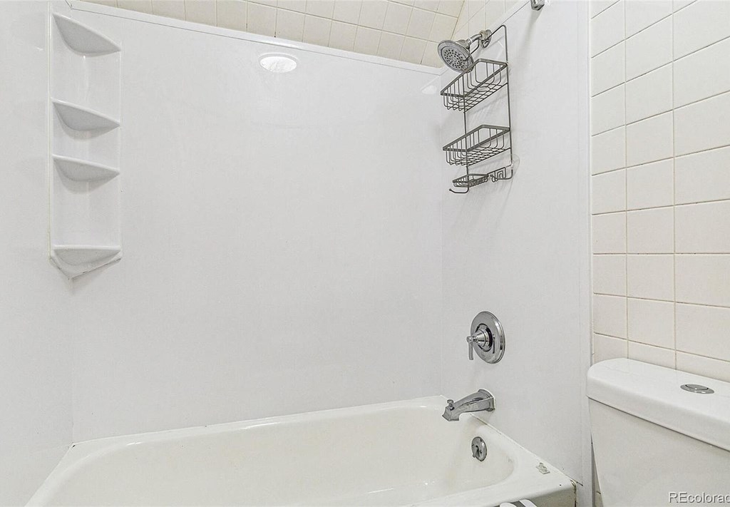 A white bathroom with a tub and a shower.