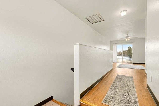 a hallway with a white wall and a door to a house