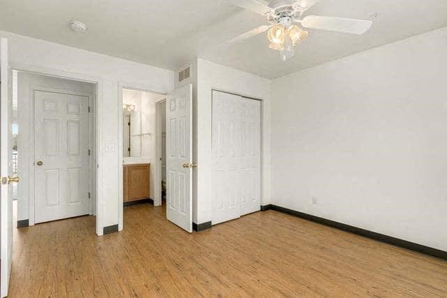 an empty living room with white walls and a ceiling fan