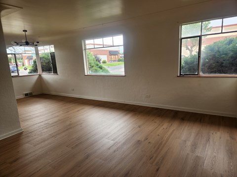 A room with wooden floors and two windows.