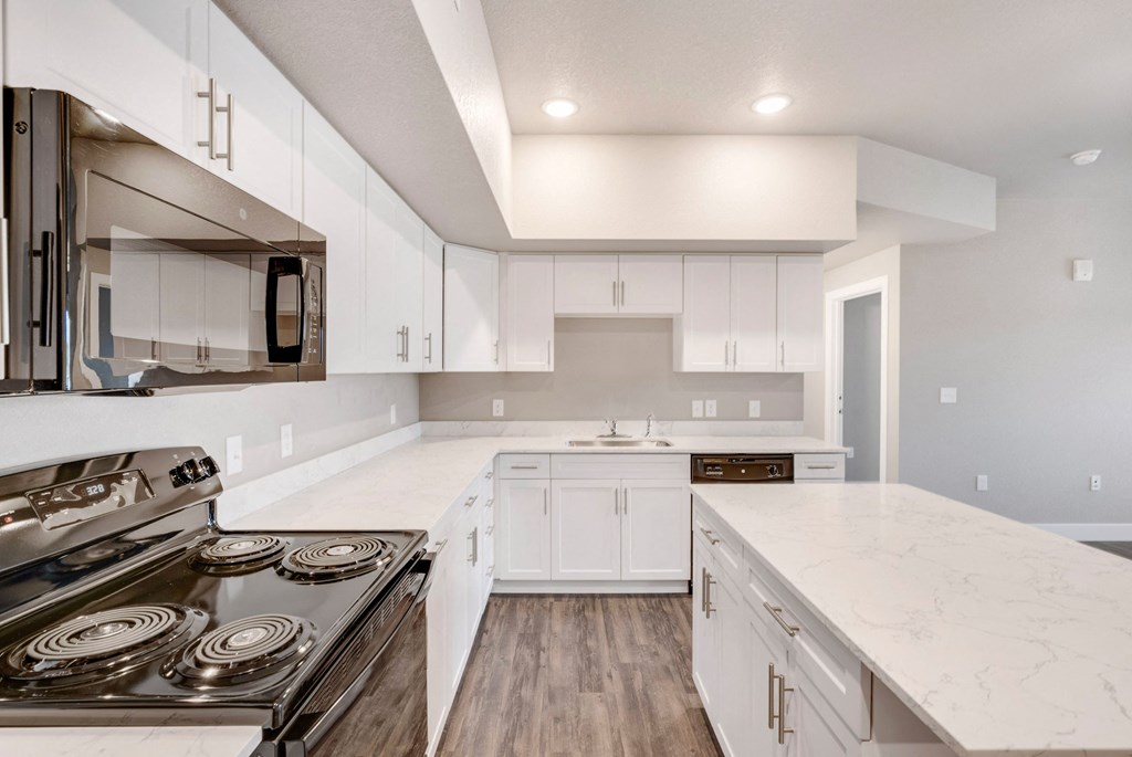 a white kitchen with white cabinets and stainless steel appliances