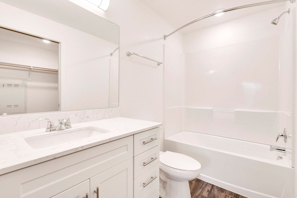 a white bathroom with a sink toilet and shower