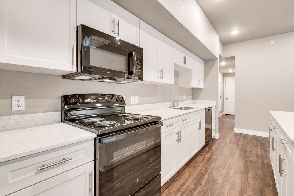 a kitchen with white cabinets and a stove and a microwave