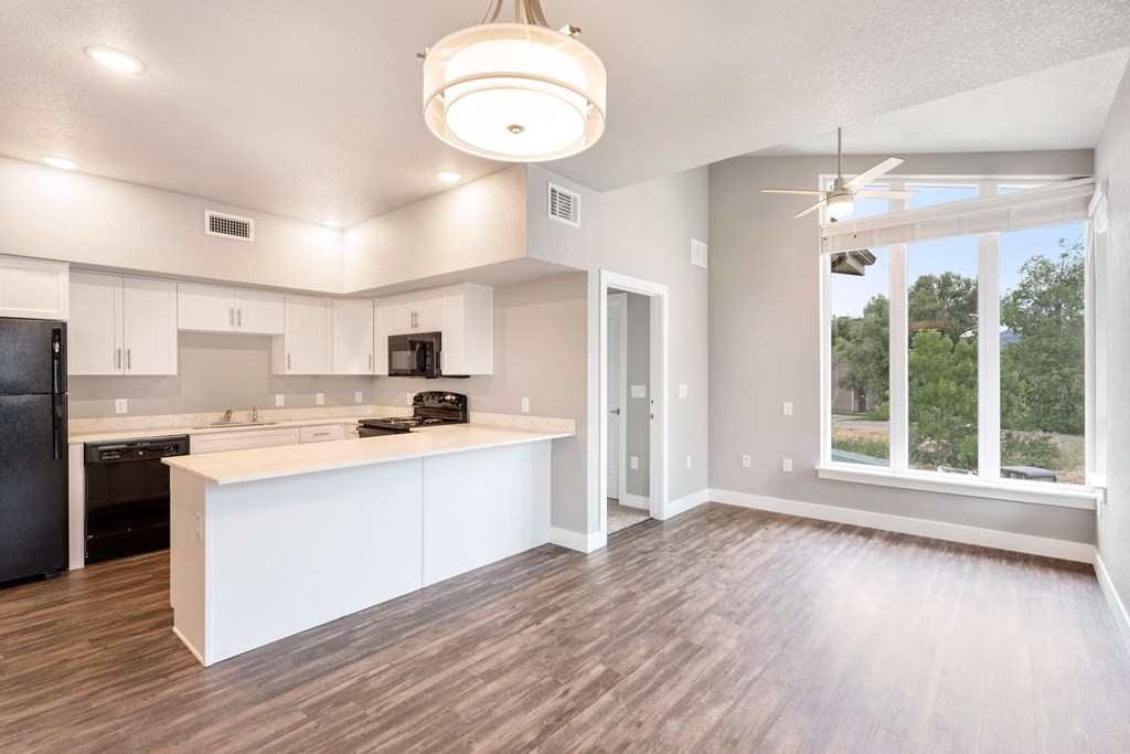 an open kitchen and living room with a large window
