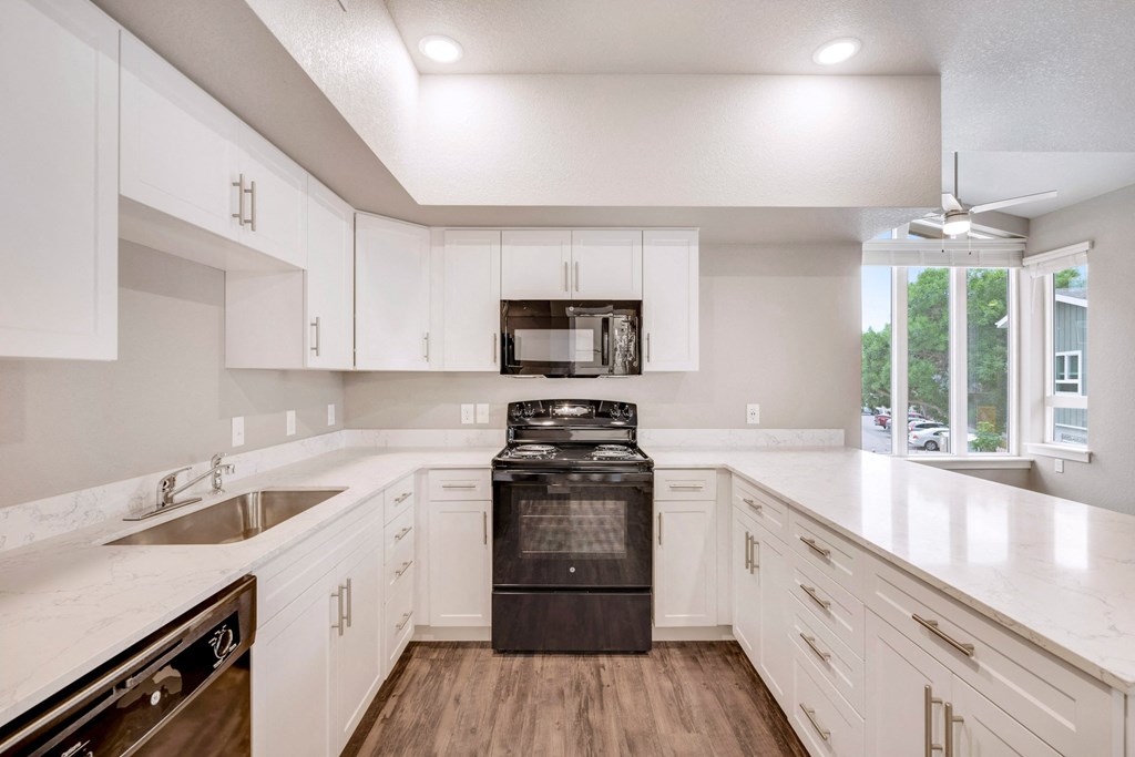 the preserve at ballantyne commons apartment kitchen with white cabinets and black appliances