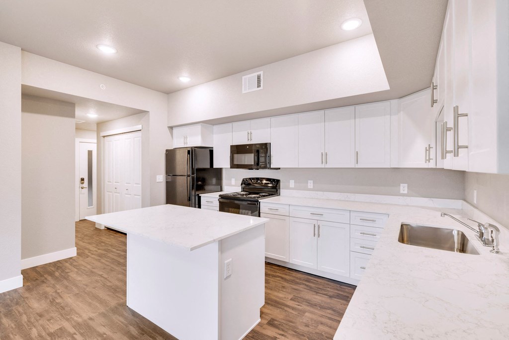 a large white kitchen with white counter tops and white cabinets