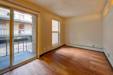 an empty living room with wood floors and a sliding glass door