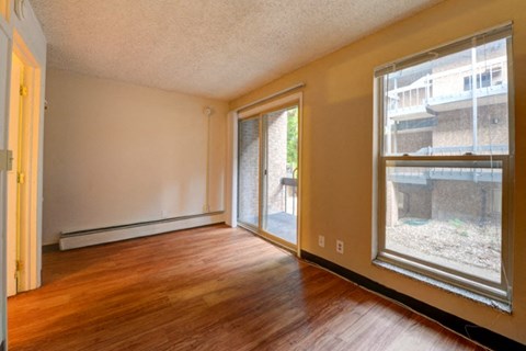 a living room with a large window and wooden floors