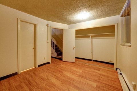 an empty room with a wood floor and a staircase