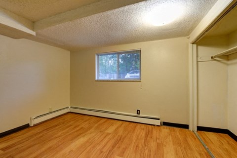 the living room of an empty house with wood floors and a window