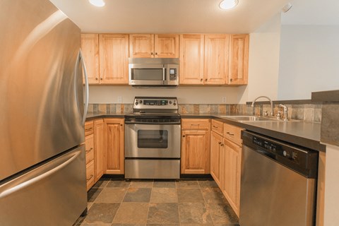 A kitchen with wooden cabinets and stainless steel appliances.
