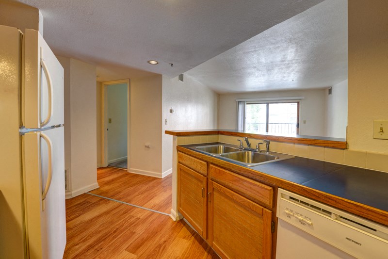 an empty kitchen with a sink and a refrigerator