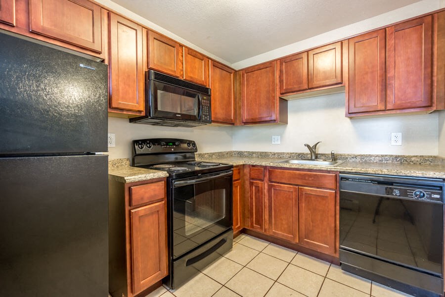 a kitchen with wood cabinets and black appliances