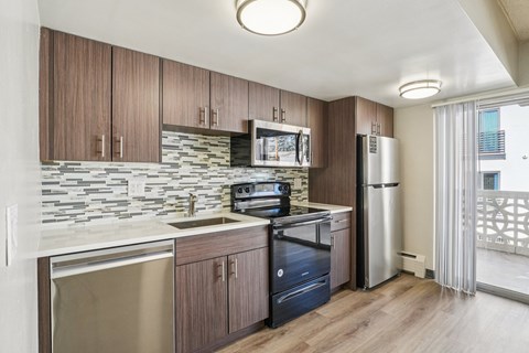A kitchen with wooden cabinets and a stone backsplash.