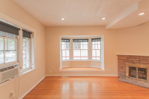 an empty living room with a fireplace and a window