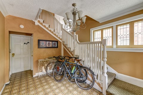 A bicycle is leaning against the banister of a staircase.