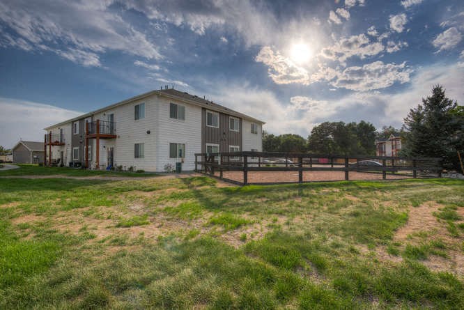 a house with a fenced in yard on a sunny day