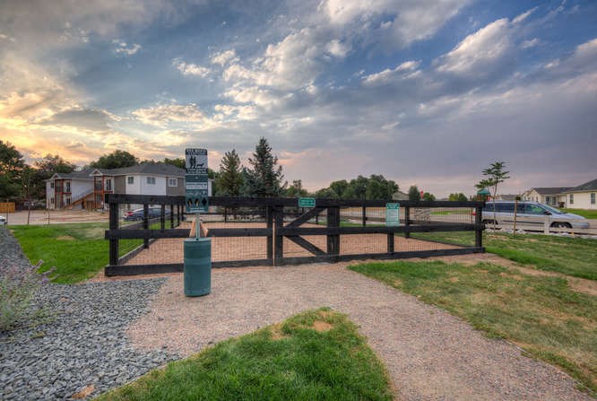 a wooden fence with a trash can in front of it