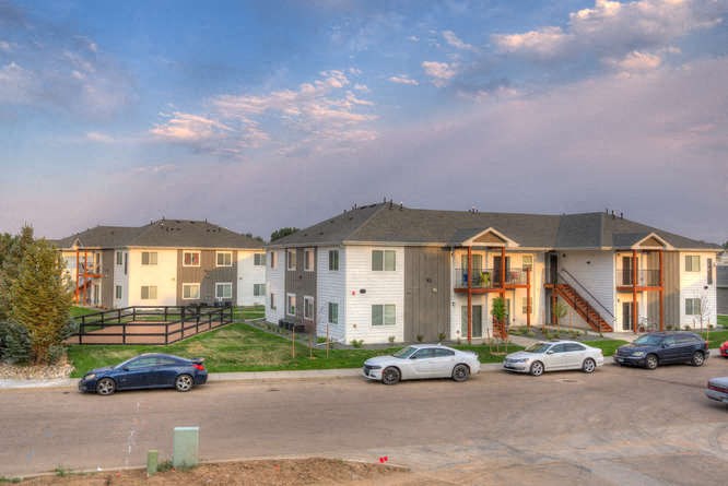a row of townhomes with cars parked in front of them