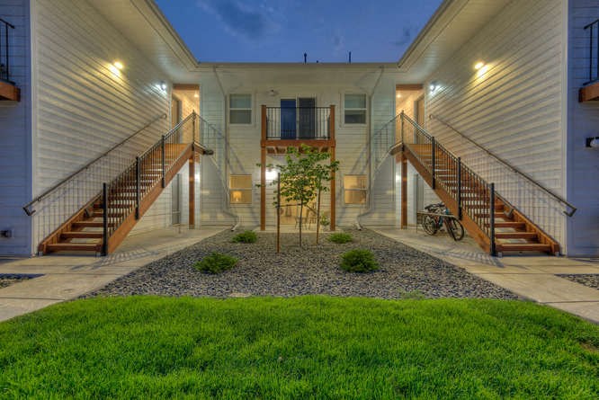 a courtyard with green grass and a bike parked in front of a building